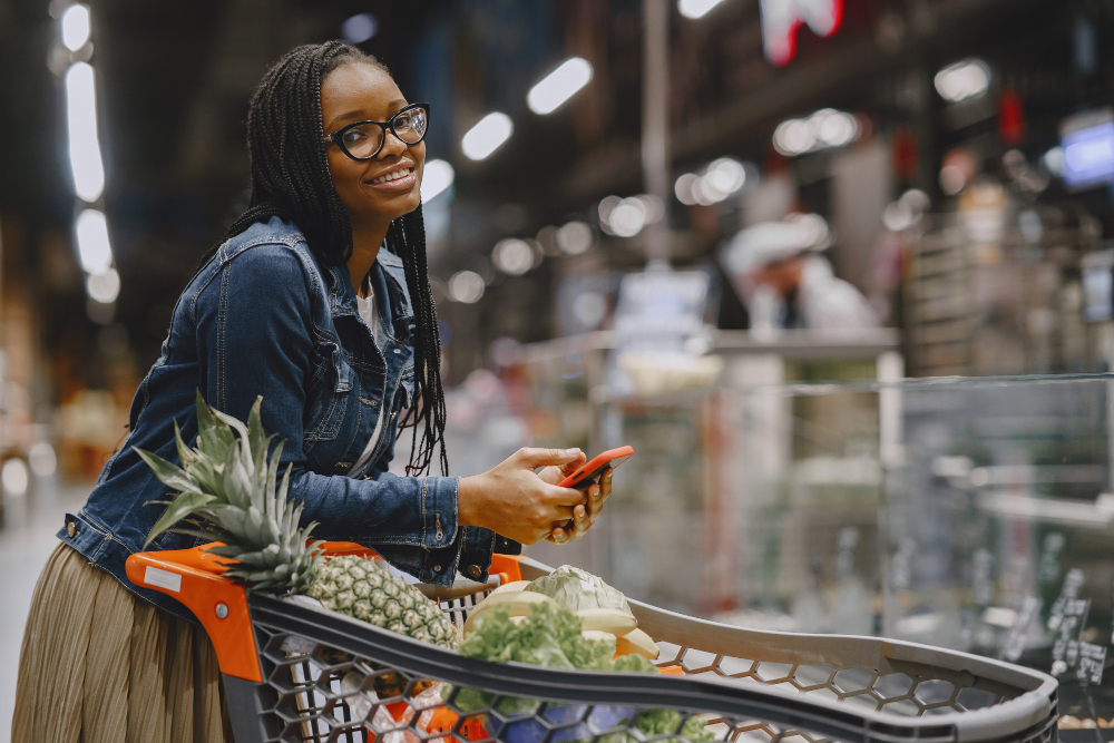 Aniversário Atacadão: Como aproveitar as ofertas para o seu negócio? | Mulher com carrinho sorrindo em supermercado | Atacadão