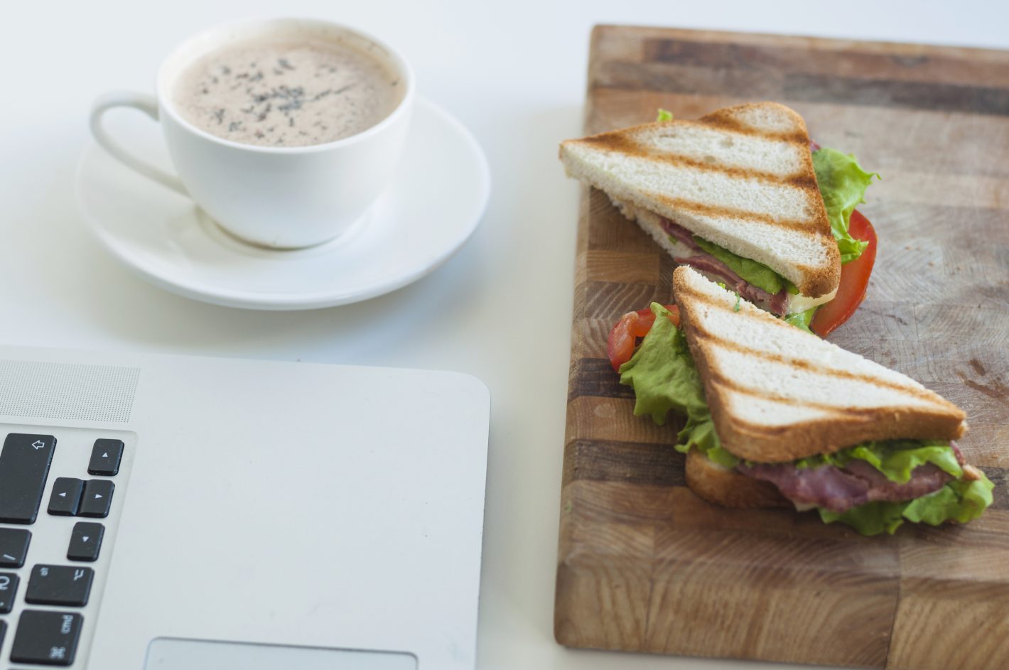 Sanduíches de café da manhã: confira opções deliciosas | Foto de dois sanduíches e uma xícara de café ao lado de um notebook | Atacadão