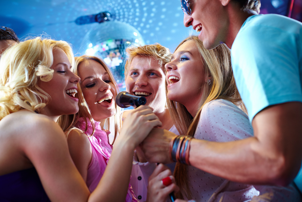 Dicas para festas de aniversário: o que comprar para o evento | Amigos cantando em Karaokê | Atacadão