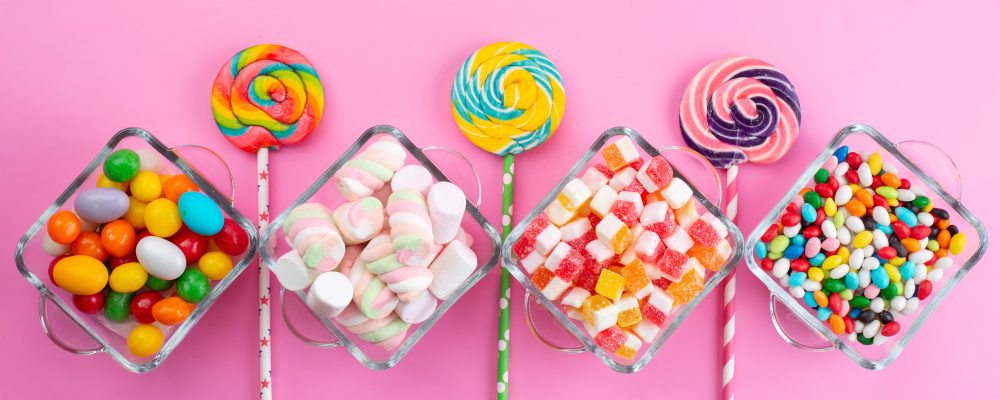 Doces para crianças: opções para presentear | Doces dispostos em uma mesa rosa | Atacadão