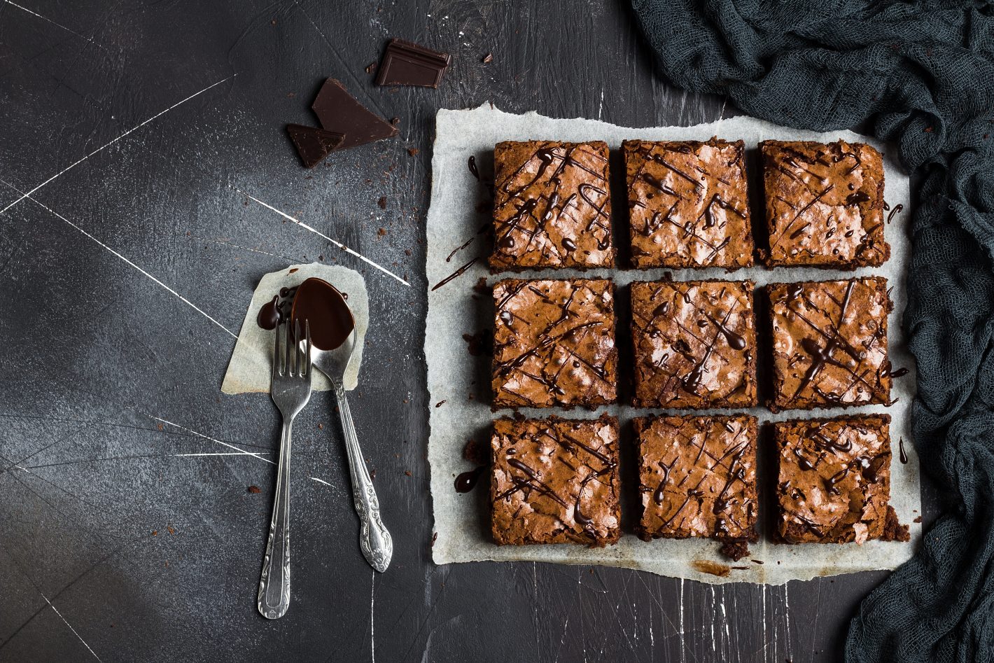 Brownies e Blondies: conheça receitas deliciosas | Foto de vários pedaços de brownies e ao lado uma colher e um garfo | Atacadão