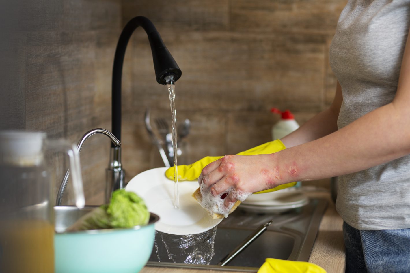 Louça engordurada: 4 dicas para lavar facilmente | Foto de uma pessoa lavando um prato | Atacadão