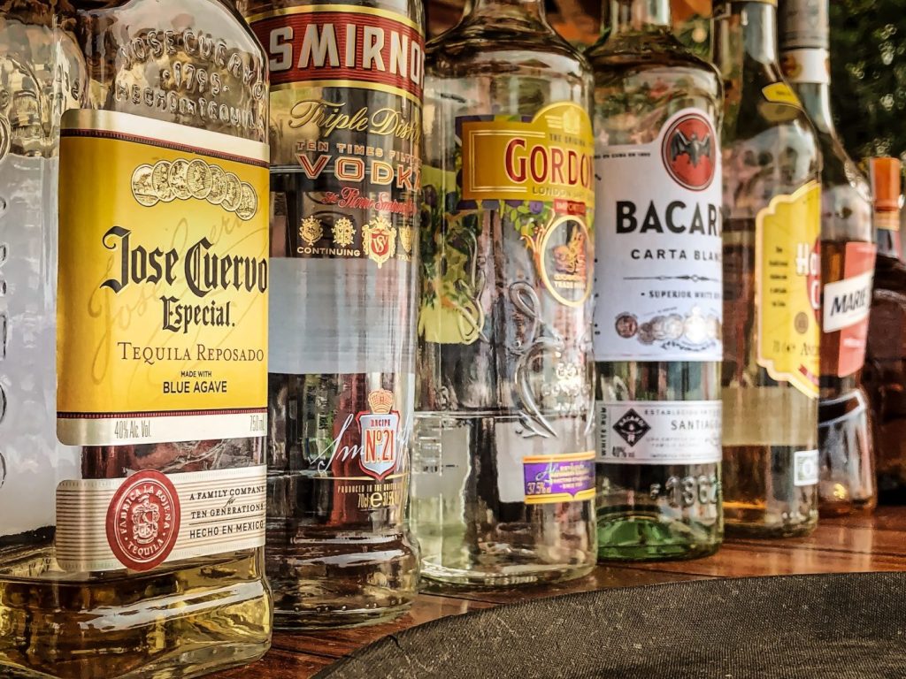 Onde comprar bebidas para revender? | Garrafas de bebida em prateleira de madeira | Atacadão