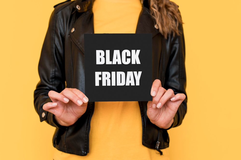 Vantagens da Black Friday: saiba por quê comprar | Mulher segurando placa da Black Friday | Atacadão