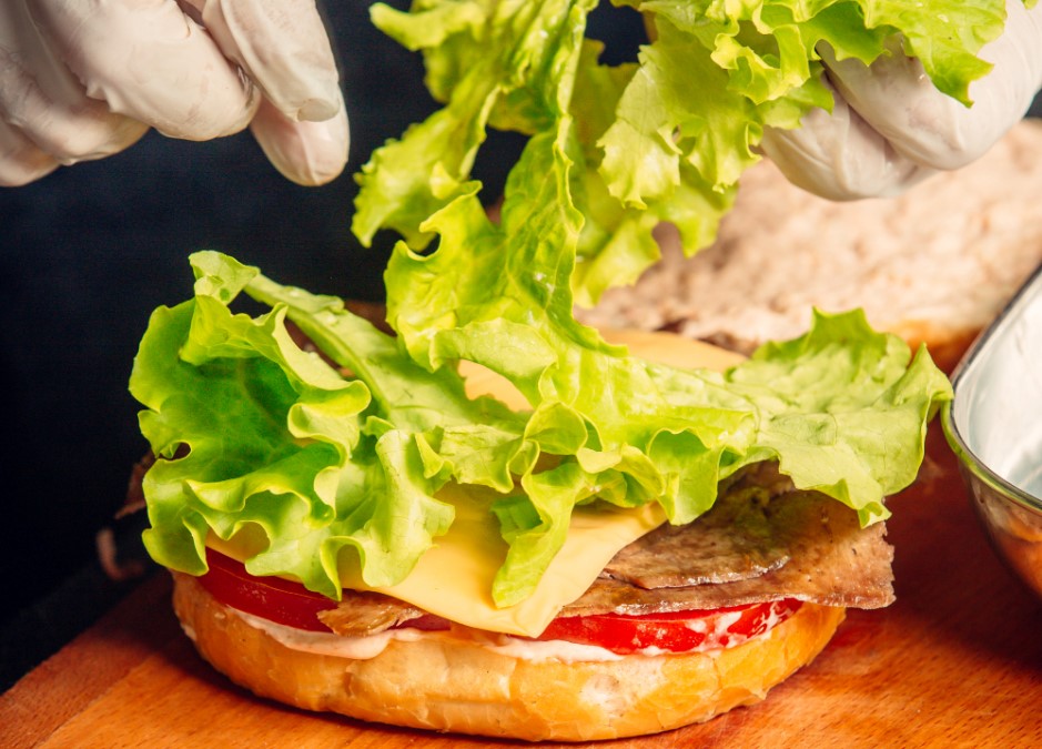 Quais ingredientes comprar para fazer hambúrguer caseiro? | Alface sendo adicionado em hambúrguer caseiro | Atacadão
