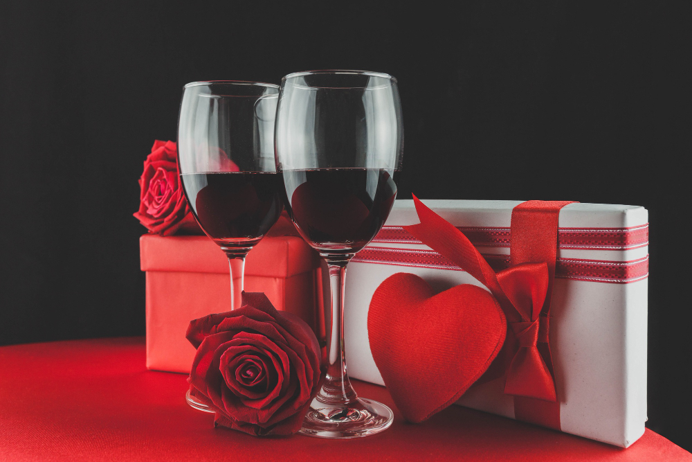 Bebidas sazonais: veja dicas de bebidas para datas especiais | Duas taças de vinho em frente a presentes românticos | Atacadão