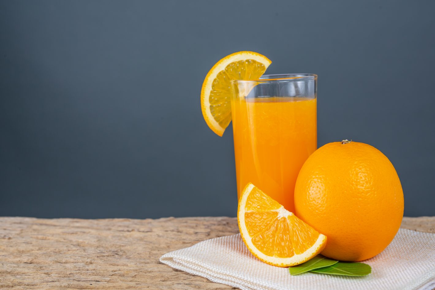Drinks com suco de laranja: conheça opções! | Foto de um copo de suco de laranja com várias laranjas em volta | Atacadão