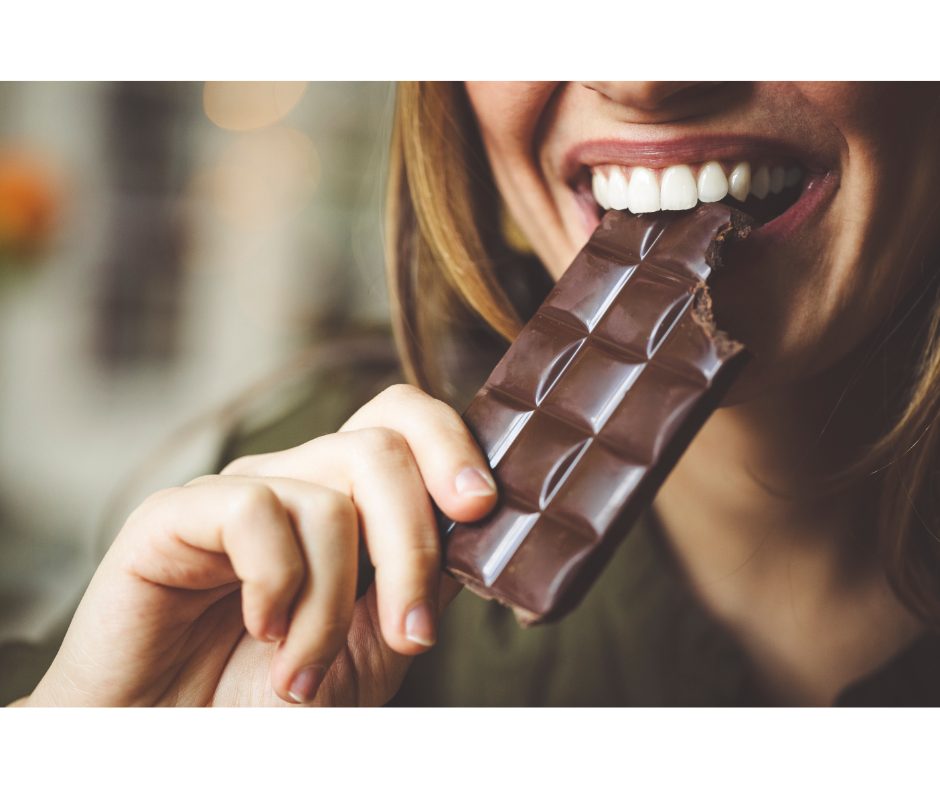 Marcas de chocolate: opções perfeitas para vender | Foto de uma mulher comendo uma barra de chocolate | Atacadão