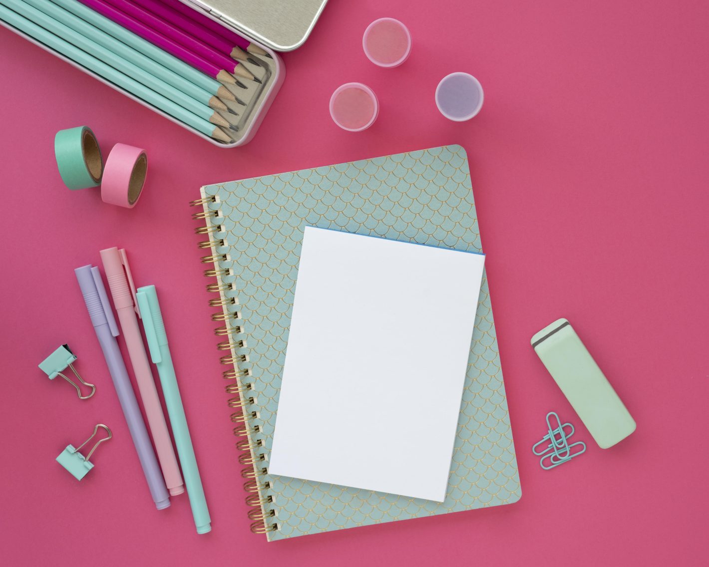 Materiais para faculdade: saiba o que não pode faltar | Foto superior de uma mesa com caderno, bloco de anotações e outros materiais escolares | Atacadão