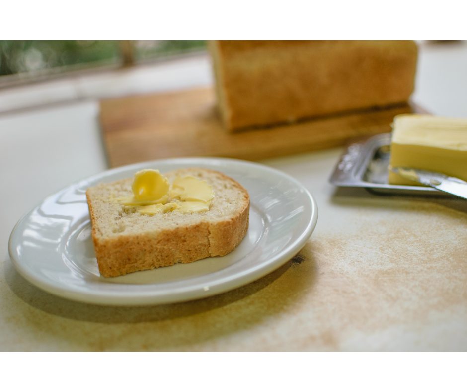 Receita de pão caseiro: aprenda a fazer | Foto de uma fatia de pão caseiro com manteiga | Atacadão