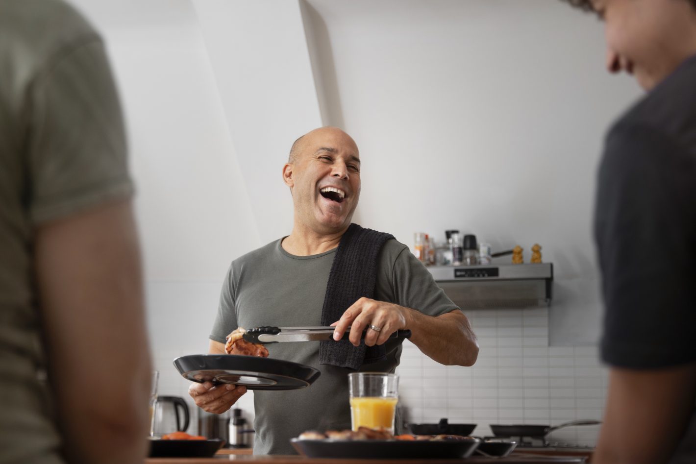 Receitas tipicamente nordestinas: conheça três opções | Foto de um homem sorrindo enquanto cozinha para seus amigos | Atacadão