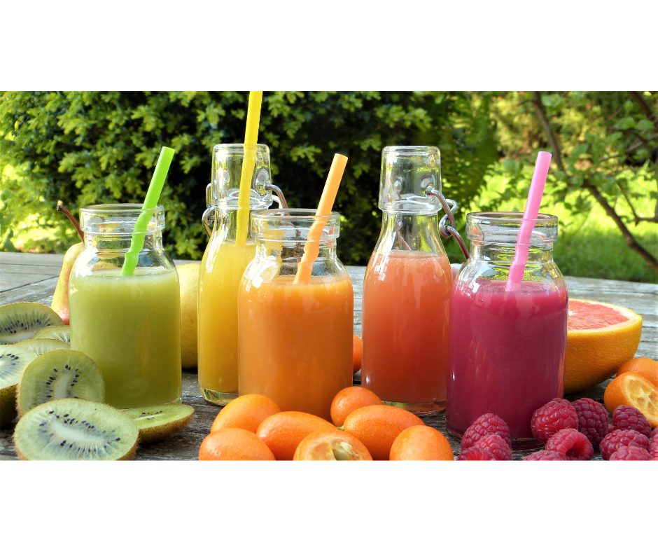 Melhores sabores de suco para vender em sua loja | Foto de uma mesa ao ar livre com garrafas de sucos e frutas | Atacadão