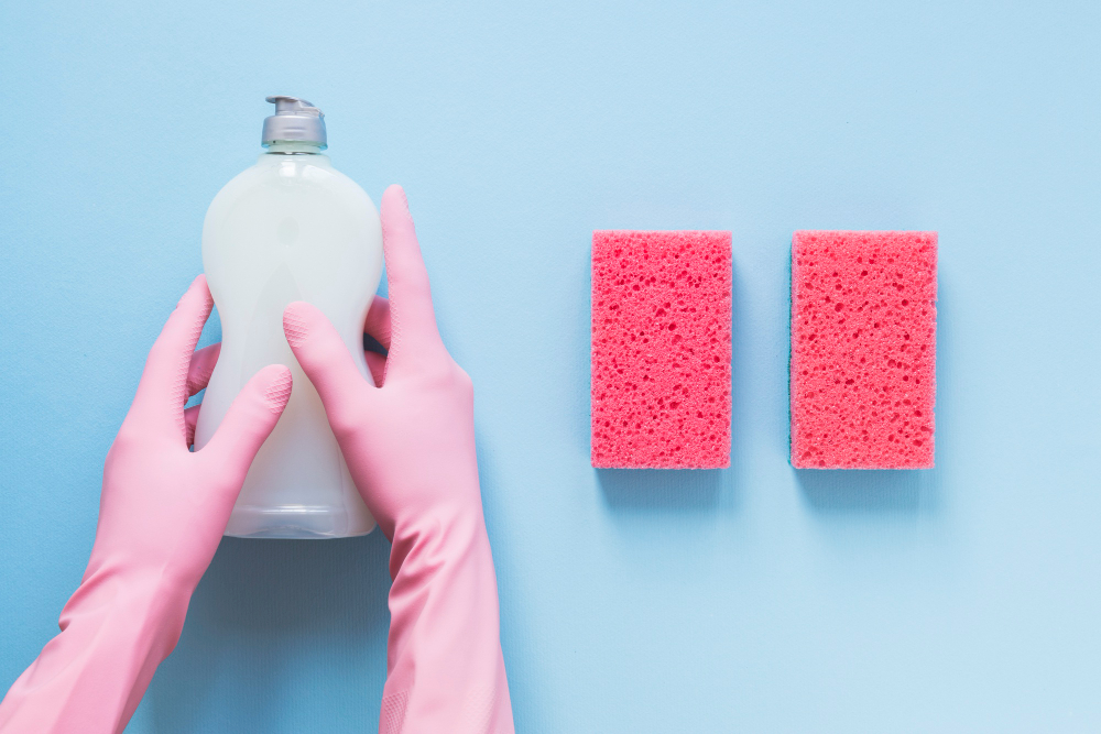 Onde utilizar detergente em casa? | Pessoa segurando detergente ao lado de duas esponjas | Atacadão