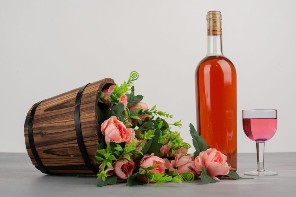 Vinhos para tomar em época de páscoa I Foto de vinho rosé acompanhado de rosas I Atacadão