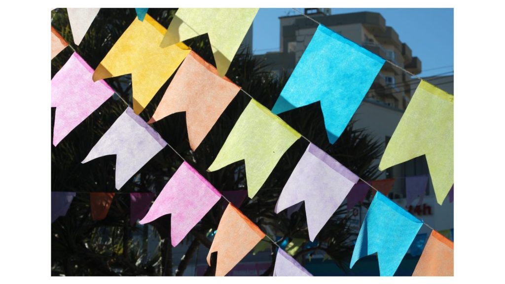 5 dicas para economizar no preparo da festa junina | Foto de varal de bandeirinhas coloridas feitas com papel. | Atacadão