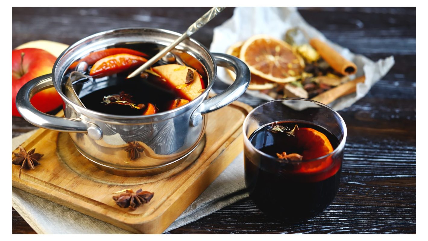 Veja quais são os melhores drinks para fazer em festa junina | Foto de uma panela e copo servidos com vinho quente. | Atacadão