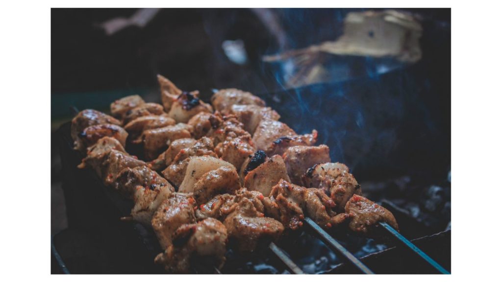 Receitas com carne vermelha para festa junina | Foto em close up de espetinhos de carne sendo preparados. | Atacadão