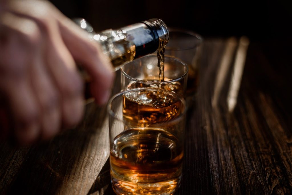 Bebidas sofisticadas: boas opções para vender | Foto em close up de whisky sendo servido | Atacadão