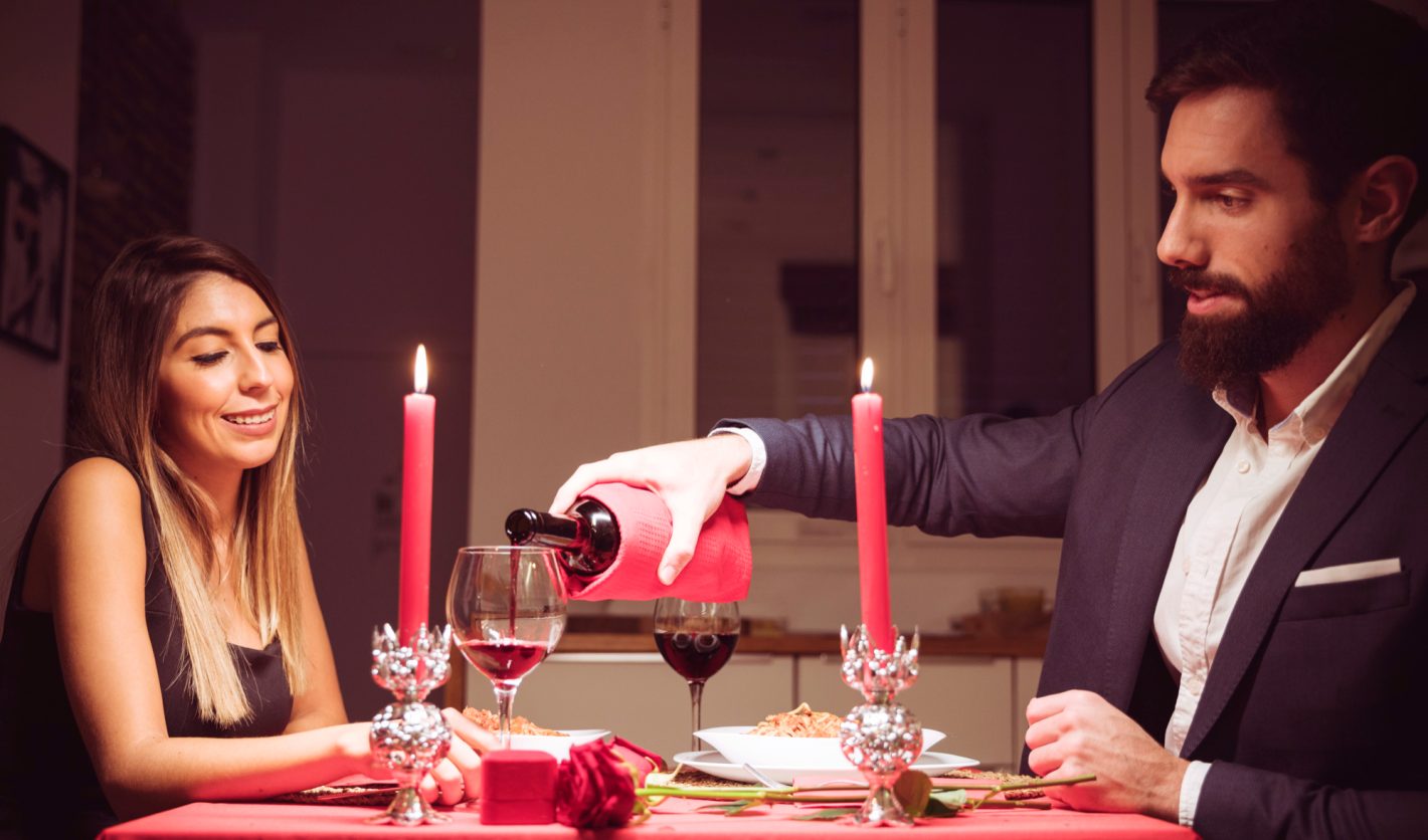 Jantar para Dia dos Namorados: como deixar o clima romântico | Foto de um casal jantando e tomando vinho a luz de velas. Atacadão