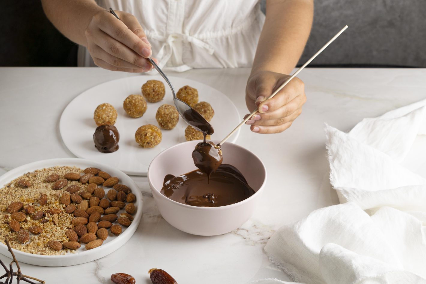Melhores dicas para produzir e vender doces | Foto das mãos de uma mulher produzindo bombons de amêndoas