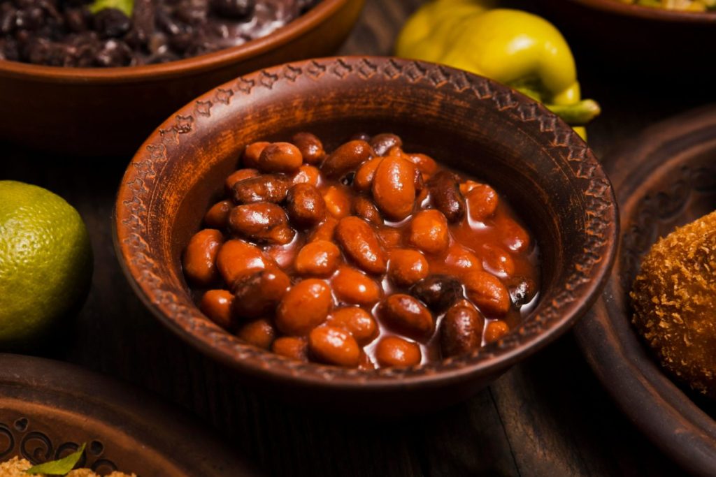 Consumo de feijão: conheça a importância do alimento | Foto de uma mini combuca de feijão cozido. | Atacadão